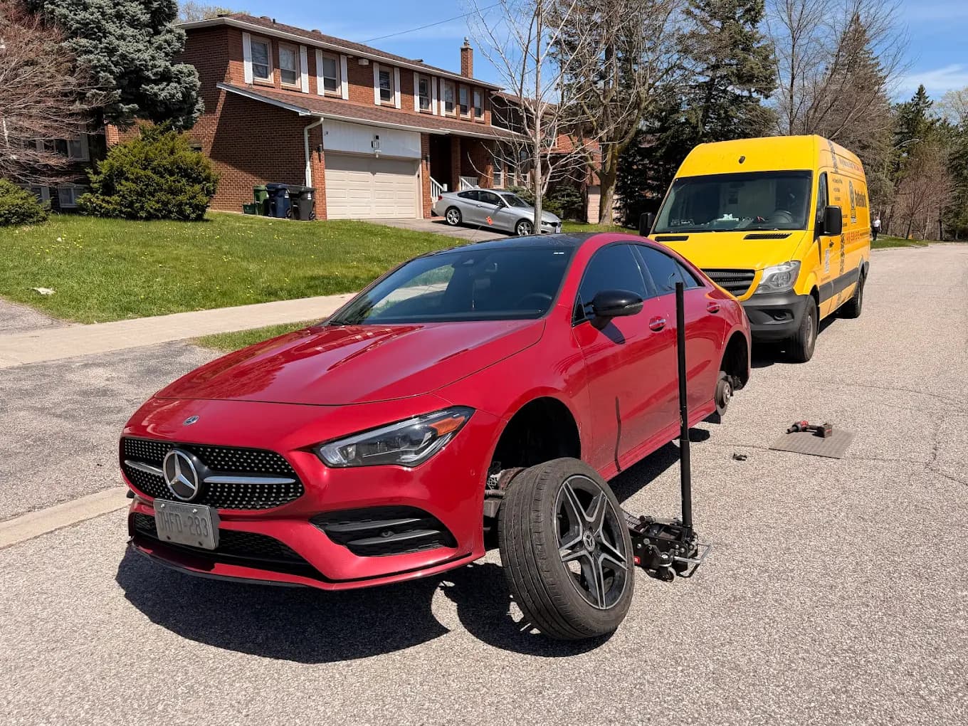 GoldenNorth mobile tire change on a red Mercedes on a GTA residential street, yellow service van parked behind