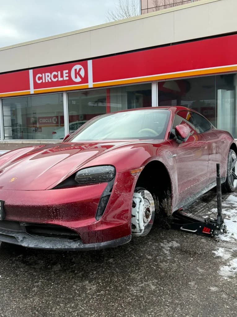 Red Porsche Taycan getting a winter tire changeover in a GTA parking lot