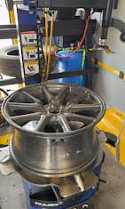 An alloy wheel mounted on the van's tire machine for balancing