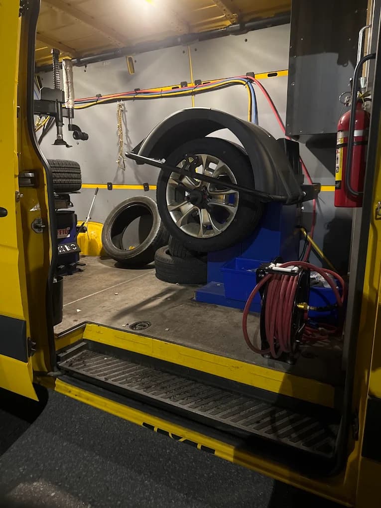 Inside the van: a tire on the balancing machine with hoses, tools and a fire extinguisher